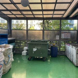 Recycling center at a Korean apartment complex with designated bins for glass, cans, plastic, vinyl, and food waste, along with a smart waste disposal system.